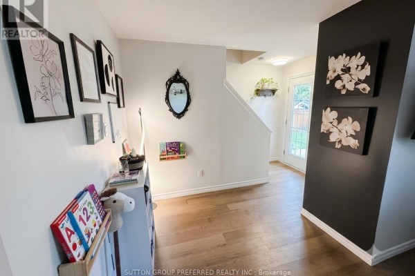 Hallway with dark accent wall, framed art, mirror, and a view of the entryway and stairs. - 27 - 825 Dundalk Drive, London South