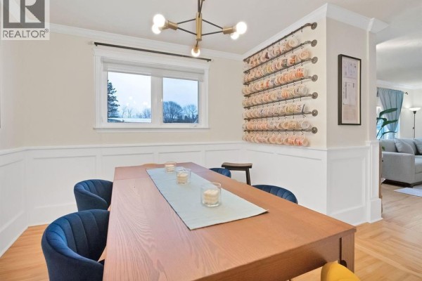 Dining room with a wooden table, blue chairs, and a window overlooking outdoors. - 27 Alphonse Street, Shediac