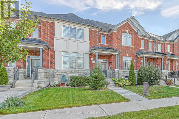 Front view of red brick townhouses with stone foundations and covered porches. - 27 Beechborough Crescent, East Gwillimbury