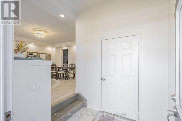 Interior view of a bright white foyer with a door leading to a dining room. - 27 Beechborough Crescent, East Gwillimbury