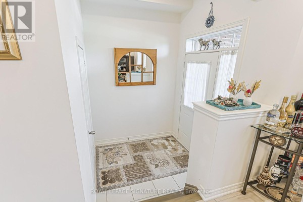 Hallway entrance with white walls, a patterned rug, and a white door to the outside. - 27 Beechborough Crescent, East Gwillimbury