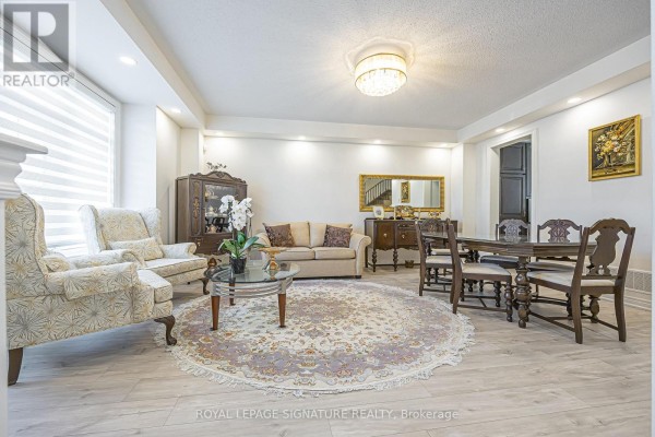 Living and dining room with light wood floors, upholstered furniture, and decorative items. - 27 Beechborough Crescent, East Gwillimbury