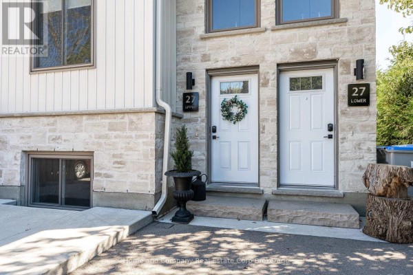 Close-up of two white front doors with "27 Upper" and "27 Lower" signs on the stone facade. - 27 Brock Street, St  Marys