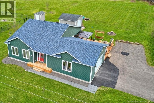 Rear exterior view of a green house with a large wooden deck, an attached garage, and a detached shed. - 27 Clement Avenue, Saint Antoine
