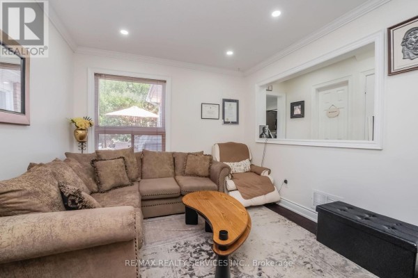 Living room with sectional sofa, recliner, and coffee table - 27 Colleyville Street Brampton