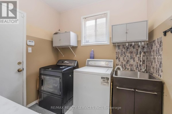 Washer, dryer, and utility sink in laundry room - 27 Colleyville Street Brampton