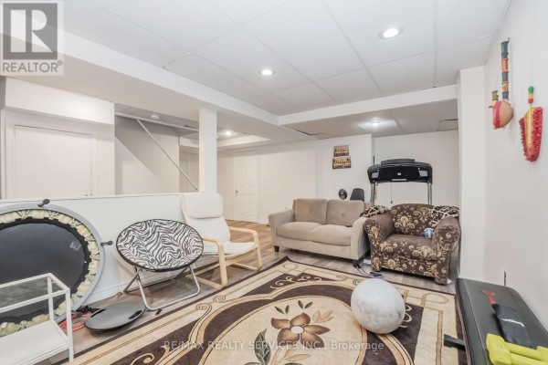 Finished basement with treadmill, sofas, and exercise equipment - 27 Colleyville Street Brampton