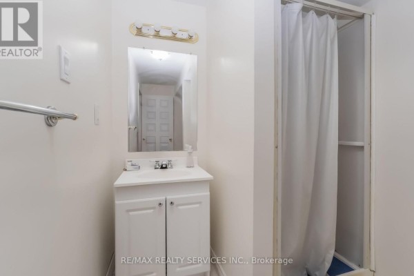 Bathroom with vanity, sink, mirror, and shower curtain - 27 Colleyville Street Brampton