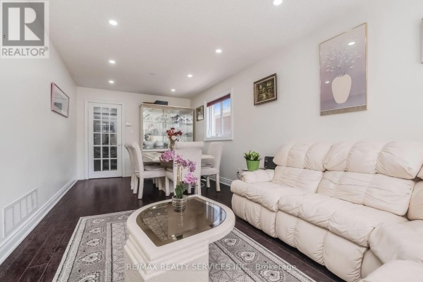 White leather sofa, dining set, and display cabinet in living room - 27 Colleyville Street Brampton