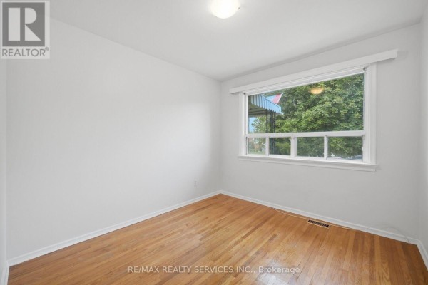 Bedroom with hardwood floors and window - 27 Edgemont Drive Brampton