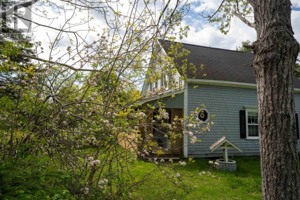 Front exterior of a light blue house with white trim and shutters, surrounded by snow. - 27 Flat Hill Roads, Broad Cove