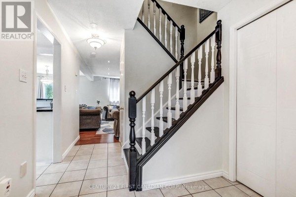 Interior foyer with tiled floor, white walls, and a dark wood staircase with white spindles. - 27 Gerald Crescent, London South