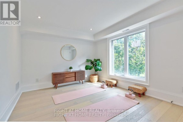 Living room with yoga mats, modern credenza, and large window - 27 Hurlingham Crescent Toronto