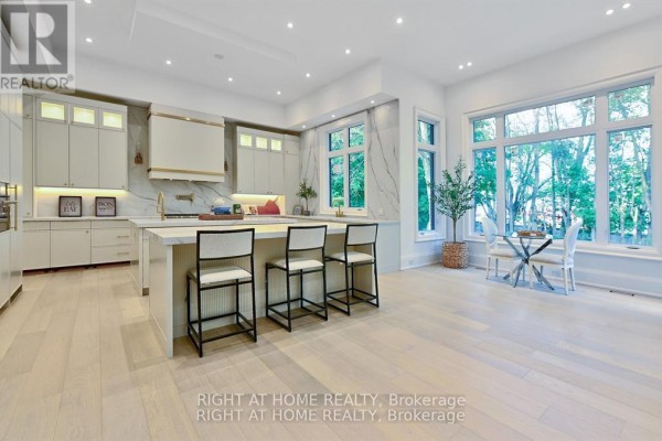Modern kitchen with island, marble backsplash, gold accents & large windows - 27 Hurlingham Crescent Toronto