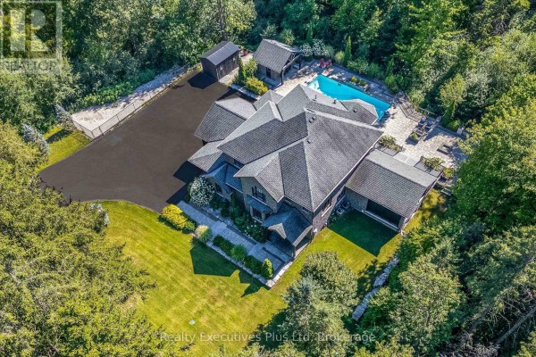 Grey stone building with five garage doors and dark metal roof. - 27 Kingfisher Crescent, Tiny
