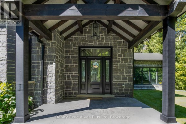 Interior foyer with white doors, wooden staircase with black railing, and glass-paned front door. - 27 Kingfisher Crescent, Tiny