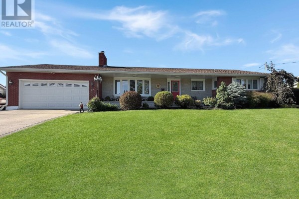 Front view of a one-story brick and stone house with a manicured lawn and trees. - 27 Lindbergh Drive, Fort Erie