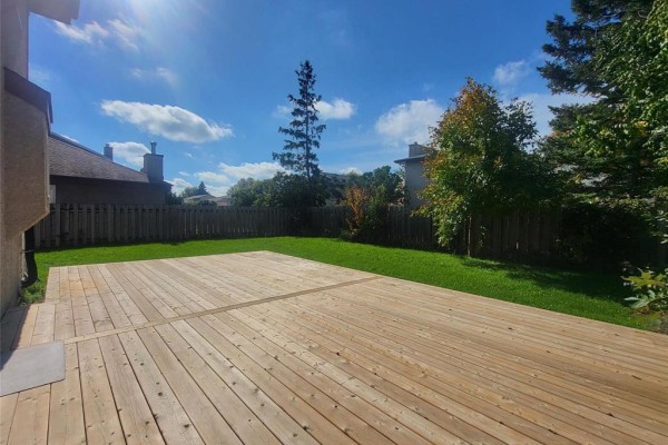 Close-up of a spacious wooden deck in a fenced backyard. - 27 Olford Crescent, Winnipeg