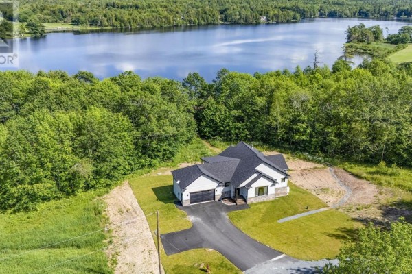 Front view of a modern white house with a dark roof, a two-car garage, and stone accents. - 27 Prettybird Lane, Oakfield