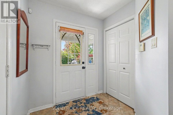 Interior view of the townhouse foyer with a tiled floor and double white doors. - 27 Randall James Drive, Ottawa