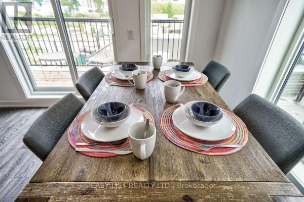 Dining area with a wooden table, grey chairs, and white walls. - 27 Spruce Pines Crescent, Toronto
