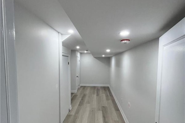 Hallway with light gray walls, white doors, and light wood-look vinyl plank flooring. - 27 William Nador Street Unit# Lower, Kitchener