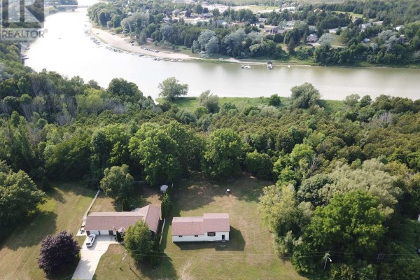 Aerial view showing houses and dense trees next to a winding river and shoreline. - 270 Edward Street, Saugeen Shores