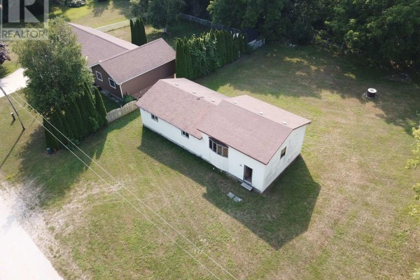 Aerial view of a long, light-colored house with a brown roof and a driveway. - 270 Edward Street, Saugeen Shores