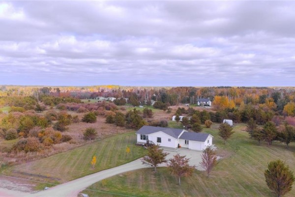 High aerial view of a white house with a grey roof, surrounded by autumn-colored trees and fields. - 270 Seine River Trail, La Broquerie