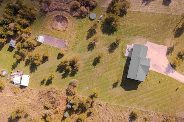 Top-down view of the property showing the house, garage, garden beds, and a small play structure. - 270 Seine River Trail, La Broquerie