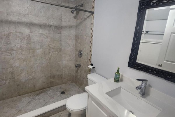 Unfinished basement room with grey walls, grey laminate flooring, and a small window. - 270 Wilson Road S, Oshawa