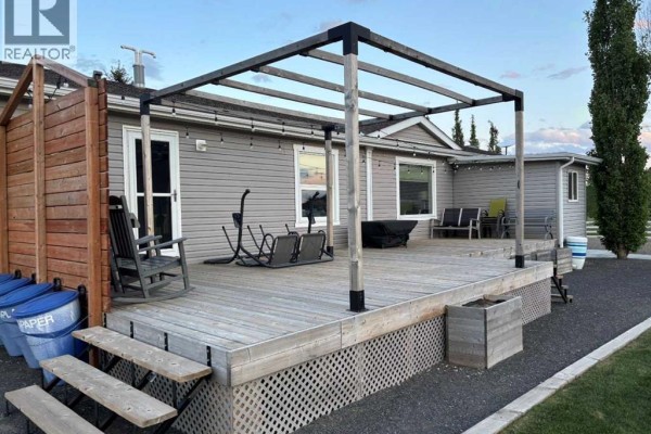 Wooden deck with a pergola, outdoor furniture, and steps leading to the yard. - 270165 Range Road 291  Se, Airdrie