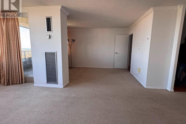 Living room with hardwood floors, a beige sofa, a white armchair, and mirrored closet doors. - 2702 - 3100 Kirwin Avenue, Mississauga