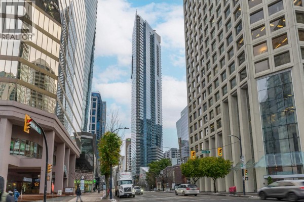 Street view of 1111 Alberni Street, a tall modern glass skyscraper, with surrounding city buildings. - 2704 1111 Alberni Street, Vancouver