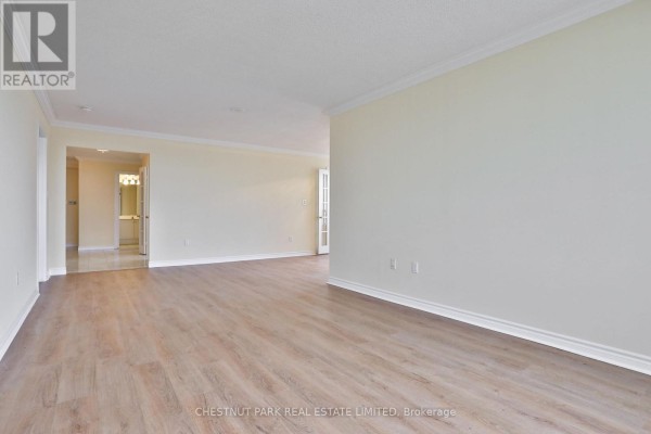 Empty apartment living space with light wood floors, pale yellow walls, and view into hallway. - 2705 - 228 Bonis Avenue E, Toronto