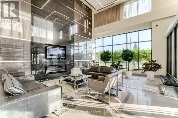Building lobby featuring a floor-to-ceiling dark marble accent wall with fireplace. - 2706 - 3975 Grand Park Drive, Mississauga