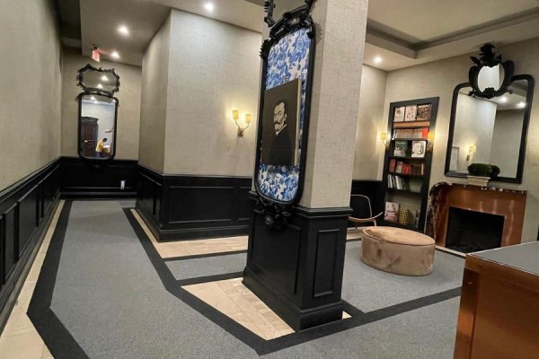 Apartment building hallway with artwork, decorative mirrors, and a small library area. - 2708 - 375 King Street W, Toronto