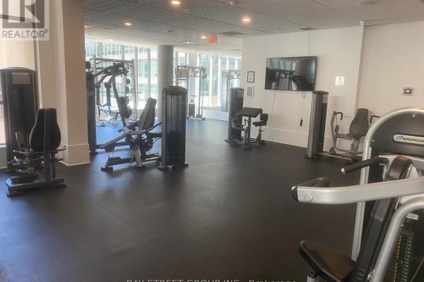 Gym with various weight machines and cardio equipment, and large windows. - 2708 - 375 King Street W, Toronto