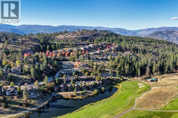 Aerial view of a suburban neighborhood with houses, a golf course, and a pond in the valley. - 271 Chicopee Road Unit# 3, Vernon