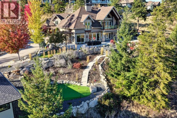 Aerial view of a house with a backyard, putting green, and sloped landscaping with stone accents. - 271 Chicopee Road Unit# 3, Vernon