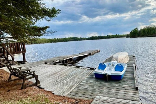 Covered deck with chairs and table overlooking a wooded area. - 271 Japada Trail, Fort Frances