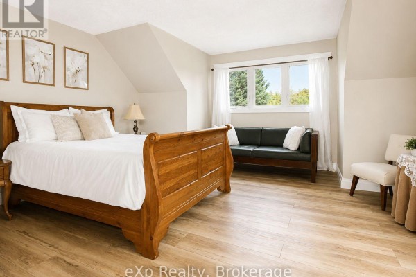 Bedroom with sleigh bed, green sofa, and large windows - 271 River Road Grey Highlands