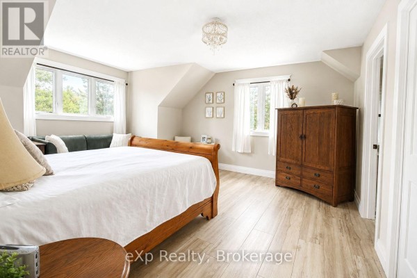 Bedroom with sleigh bed, sofa, armoire, and wood floors - 271 River Road Grey Highlands