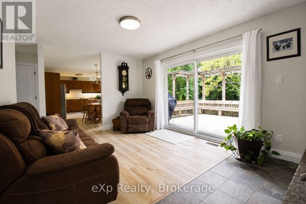 Living room with sofa, recliner, deck access, and kitchen view - 271 River Road Grey Highlands
