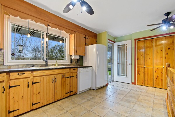 Kitchen with light wood cabinets, white appliances, a window overlooking the yard, and double doors. - 271 Rue Leguerrier O., Mansfield Et Pontefract
