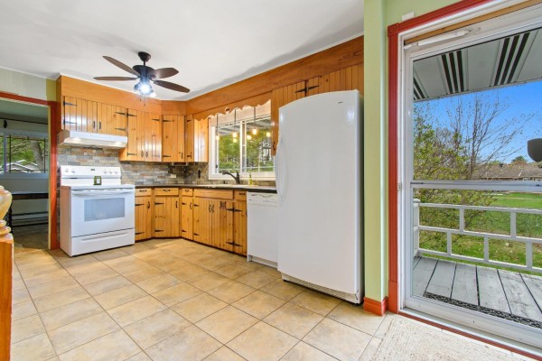 View of a kitchen with light wood cabinets, a stove, dishwasher, and a screened-in porch door. - 271 Rue Leguerrier O., Mansfield Et Pontefract
