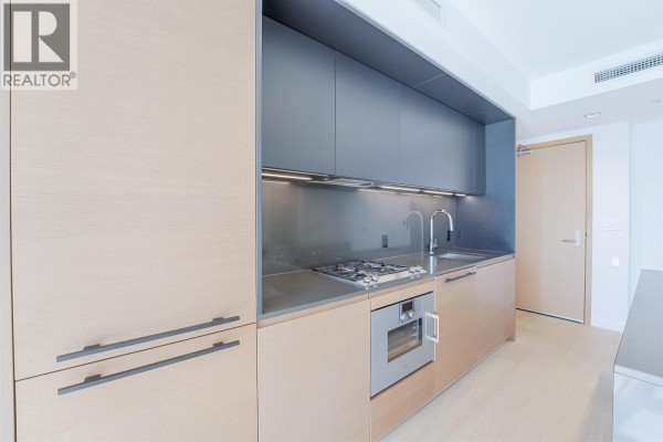 Modern apartment hallway with large white closets and light wood doors, leading to city view. - 2710 1289 Hornby Street, Vancouver
