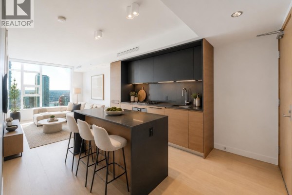 View of modern kitchen with light wood cabinets, grey countertops, and city view window. - 2710 1289 Hornby Street, Vancouver