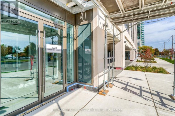 Glass entrance doors and scaffolding at the base of a modern apartment building. - 2711 - 1926 Lake Shore Boulevard, Toronto