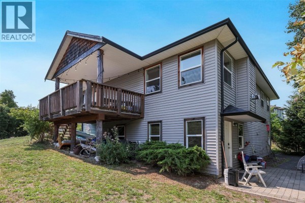 Rear exterior of the house with a wooden deck on the upper level and grey siding. - 2712 Rydal Ave, Cumberland